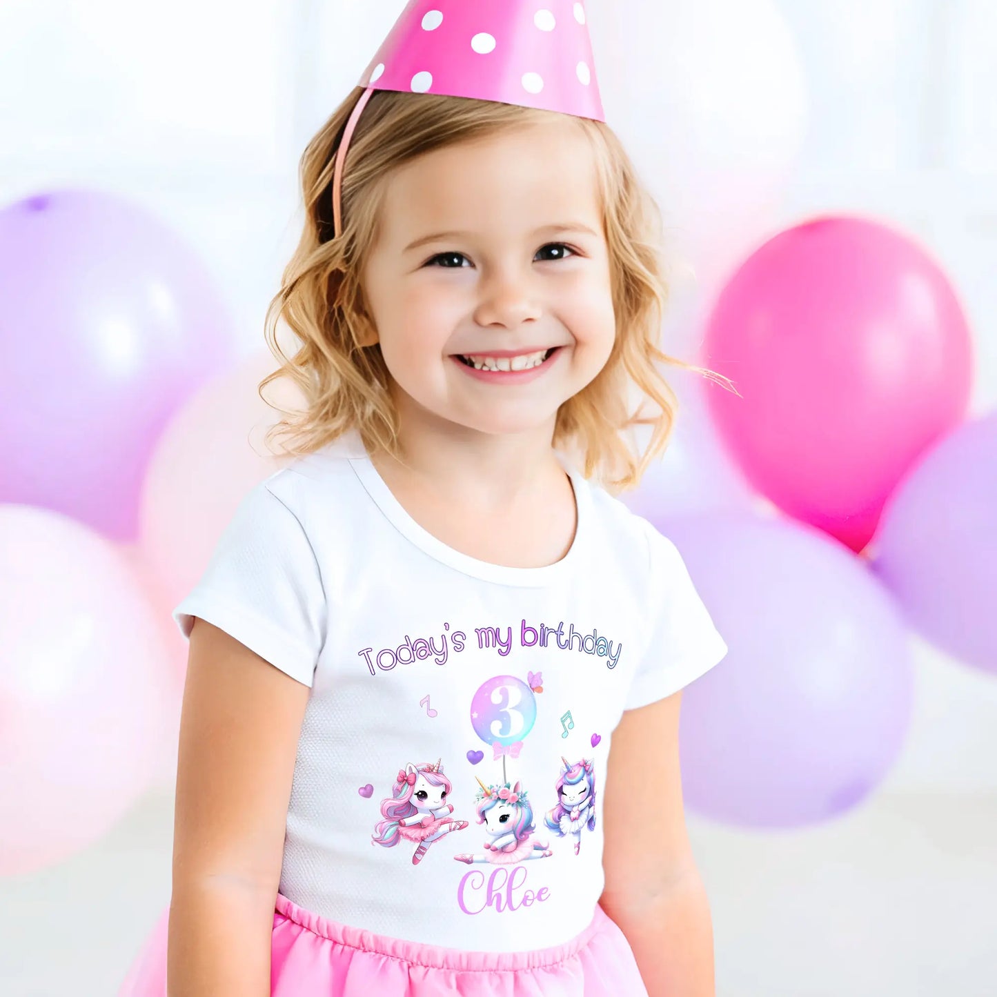 A pastel pink and lilac unicorn birthday T-shirt for girls and toddlers, featuring a cute unicorn design. Made from soft, breathable 100% cotton, this shirt offers both style and comfort. It can be personalised with a name, making it a unique birthday gift for girls. Perfect for a little dancer's birthday celebration, combining magic and comfort as she twirls and plays. Unicorn birthday gift, personalised unicorn, custom name tshirt