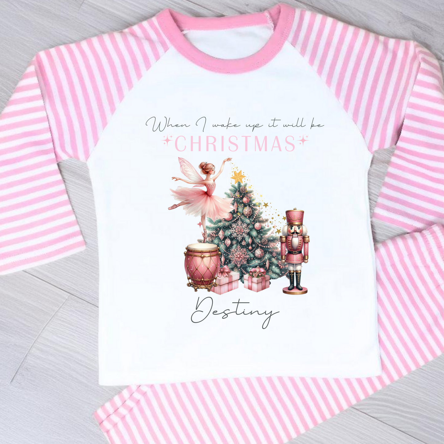 Girls personalised Christmas pyjamas featuring a beautifully illustrated ballerina as a Christmas fairy in dusky pink hues with nutcracker motifs in gold. These enchanting pyjamas offer a personalisation option to add a name, making them unique and ideal for gifting. Perfect for the Christmas season, they bring joy and become a treasured keepsake. Personalised Nutcracker Christmas Pyjamas, when i wake up it will be christmas