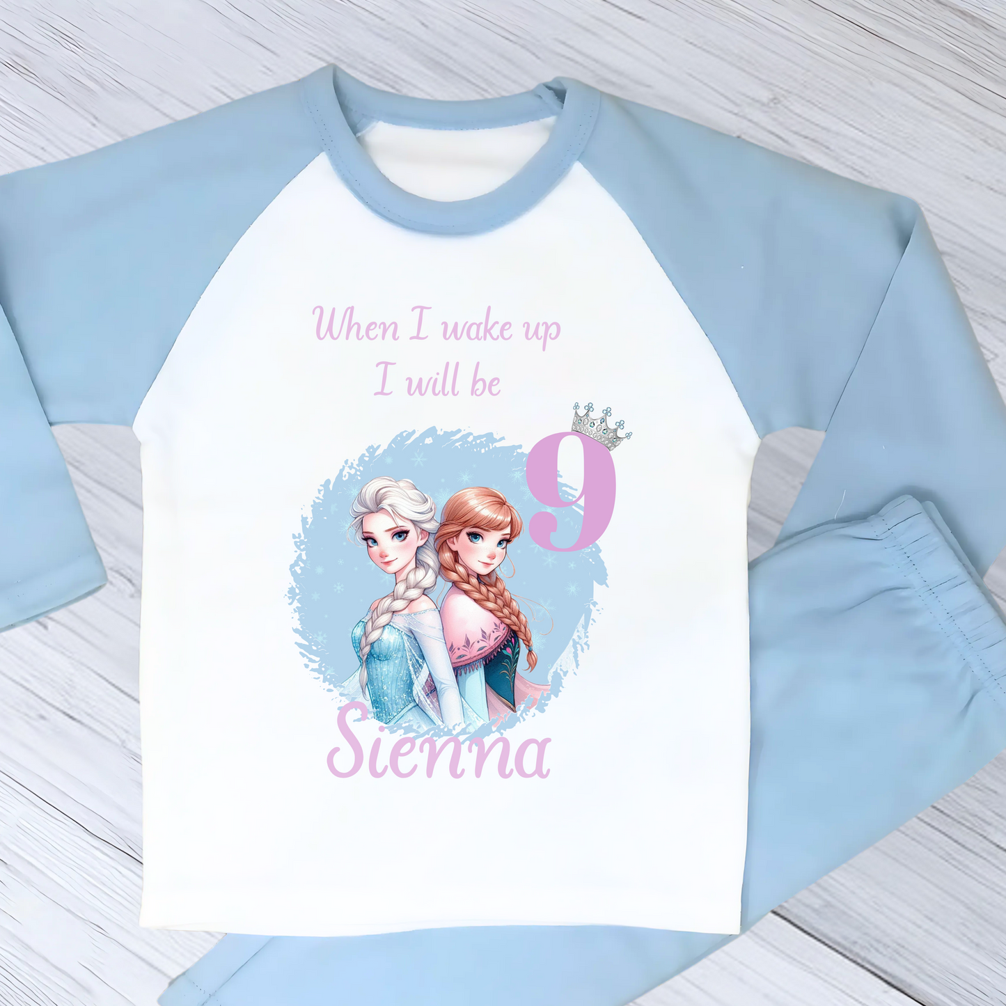 Personalised Frozen birthday pyjamas with name and age. Features Elsa and Anna in Frozen colours of blue and lilac. Perfect for birthday morning photos and celebrations.