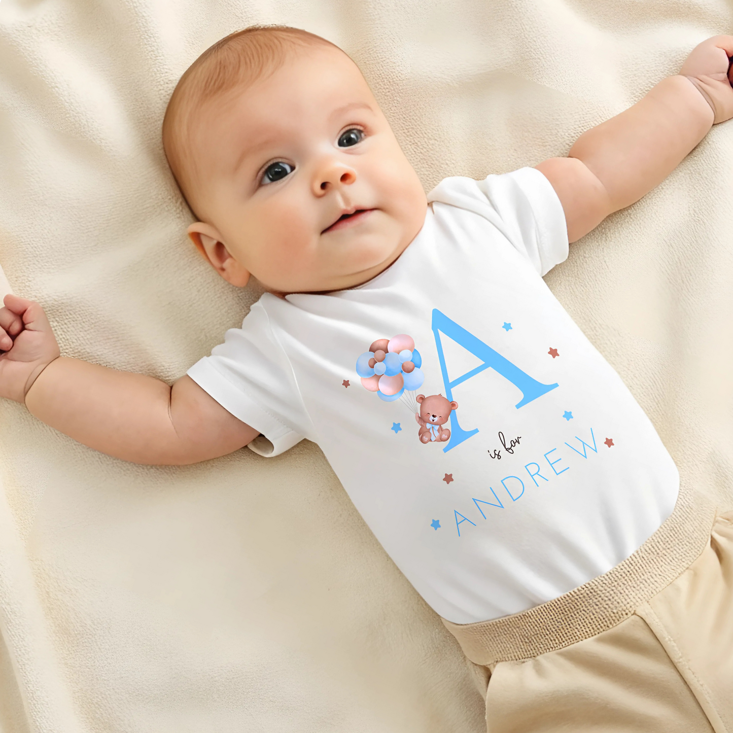 personalised baby outfit: A personalised baby boy outfit featuring a blue balloon bear design with baby name initial. Available as a sleepsuit, bodysuit, T-shirt, or bib, this charming new baby gift is perfect for a coming home outfit or gender reveal celebration.