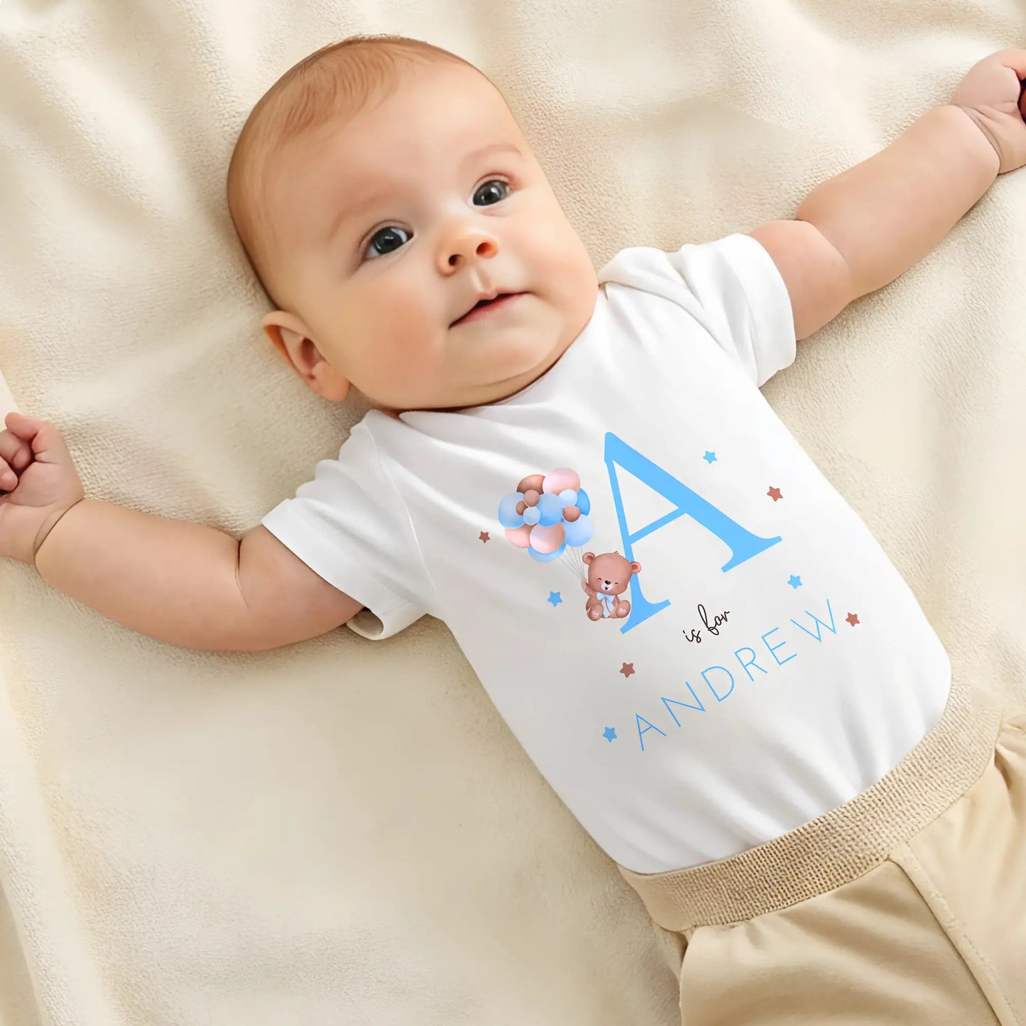 personalised baby outfit: A personalised baby boy outfit featuring a blue balloon bear design with baby name initial. Available as a sleepsuit, bodysuit, T-shirt, or bib, this charming new baby gift is perfect for a coming home outfit or gender reveal celebration.