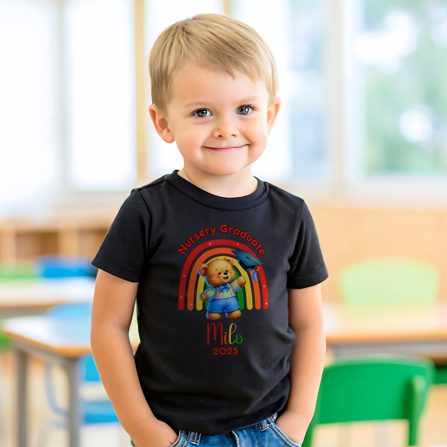 A girl wearing a white Personalised Nursery Leavers T-shirt. Above the rainbow it says Nursery Graduate and below it is a girl bear in graduation clothes on soft fluffy clouds. Below the design is the girls name and year of graduation.