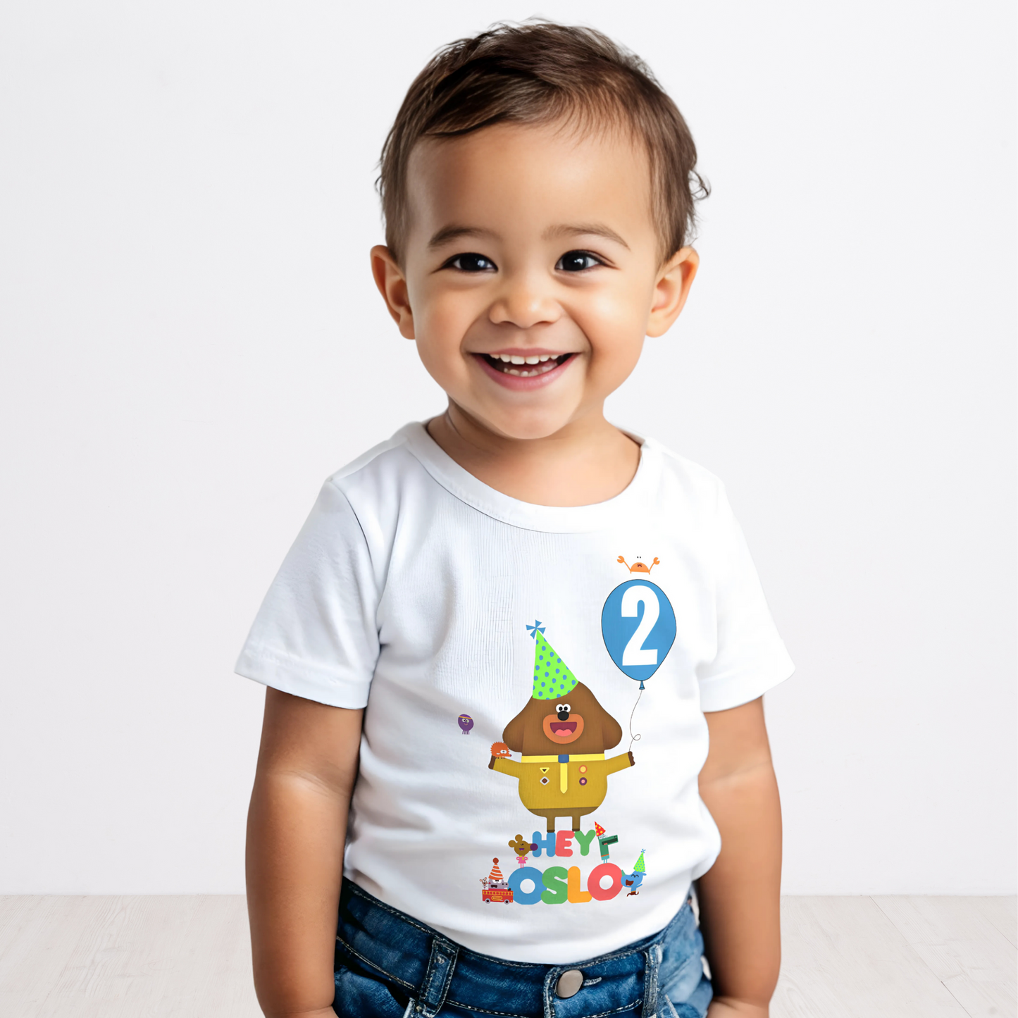 hey duggee birthday t-shirt: A vibrant and colourful Hey Duggee birthday t-shirt for boys, featuring Hey Duggee and the Squirrels. The toddler birthday shirt is personalised with the child's name and age, displayed within a cheerful blue balloon. Toddler birthday t-shirt, gift ideas for toddlers, personalised hey duggee shirt
