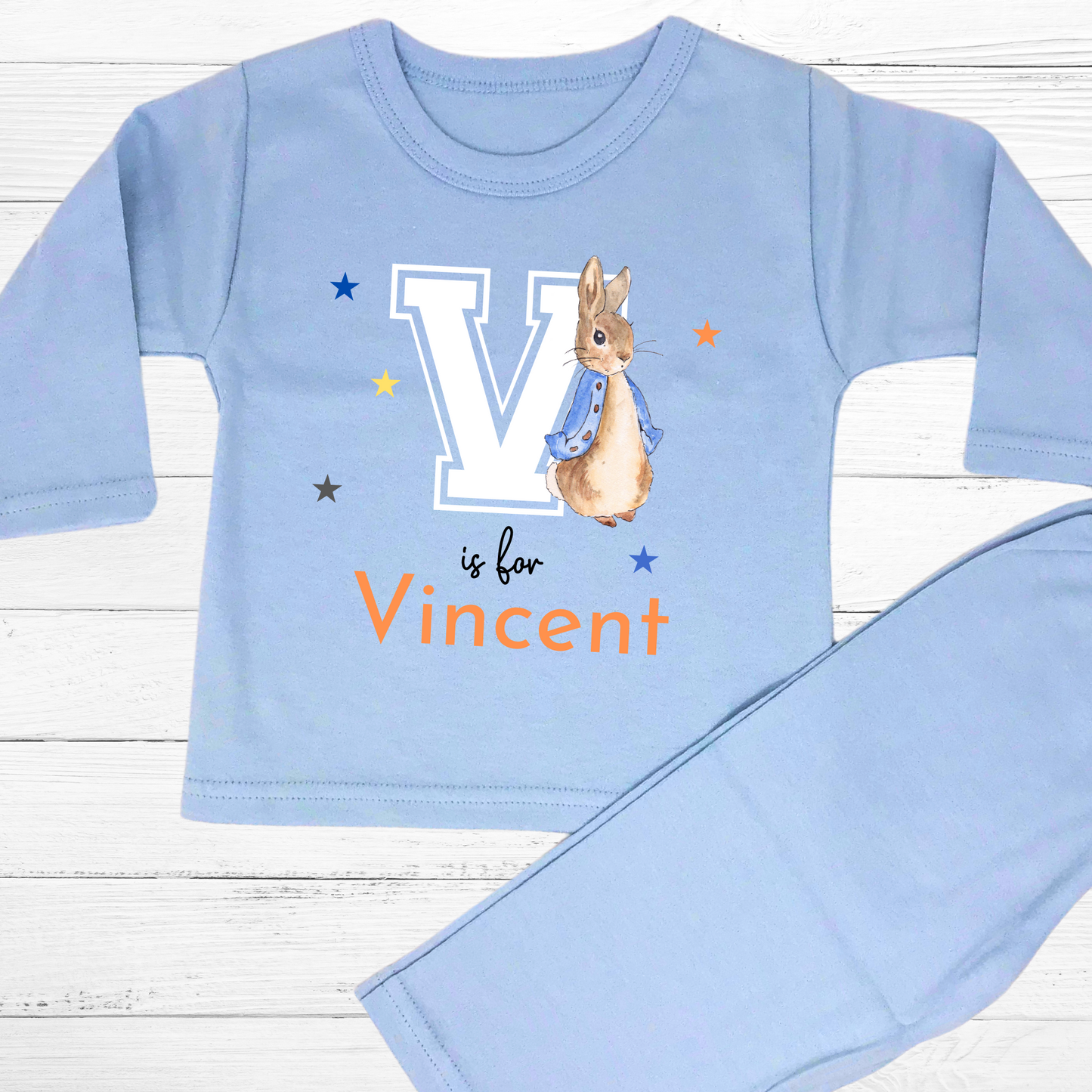 Personalised baby pyjamas: Blue Peter Rabbit-themed varsity-style pyjamas for baby boys, featuring a personalised initial and name. Designed for ages 0-2 years, this custom sleepwear set makes a thoughtful new baby gift. Ideal for personalised baby clothing, custom baby boys; clothes, and unique baby gifts.