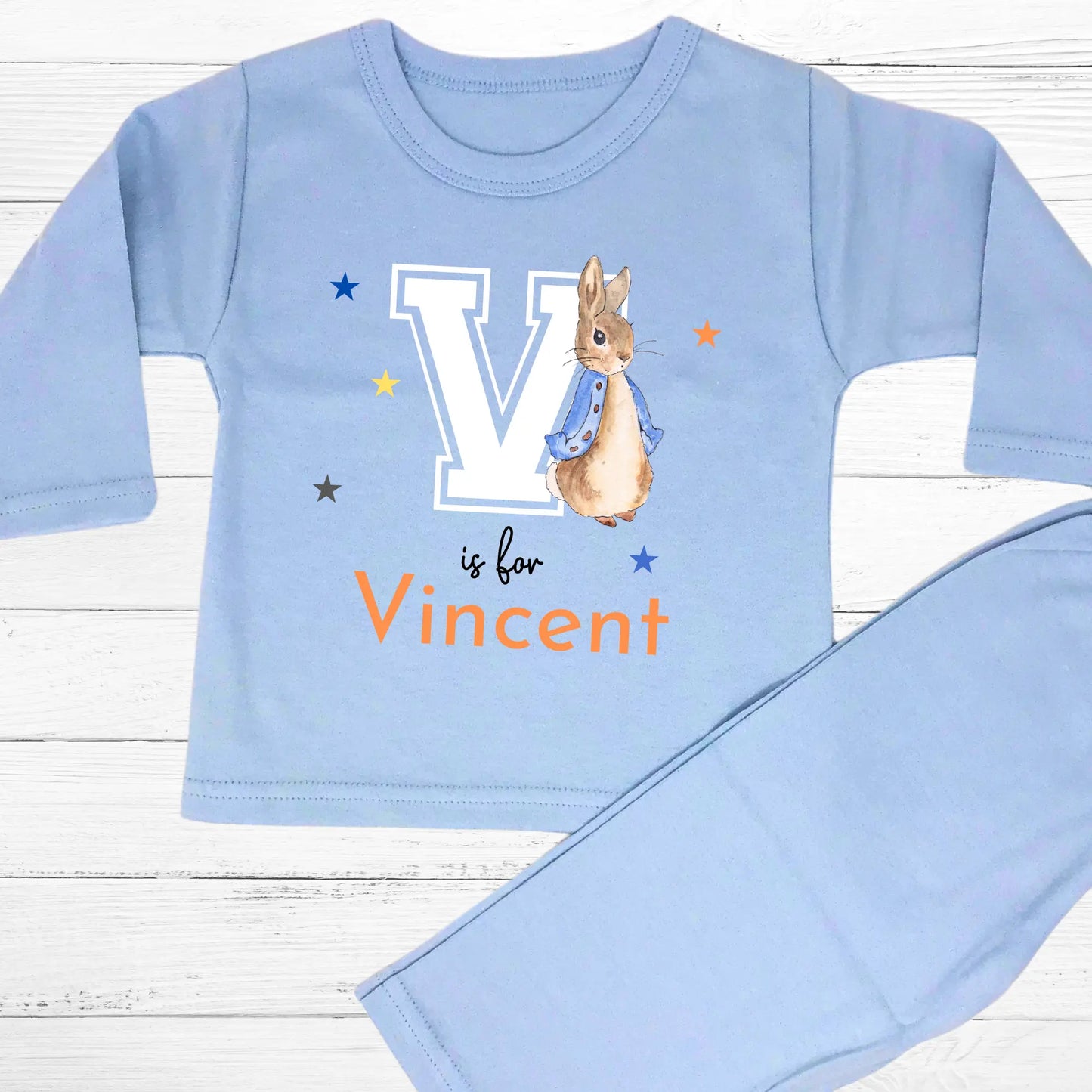 Personalised baby pyjamas: Blue Peter Rabbit-themed varsity-style pyjamas for baby boys, featuring a personalised initial and name. Designed for ages 0-2 years, this custom sleepwear set makes a thoughtful new baby gift. Ideal for personalised baby clothing, custom baby boys; clothes, and unique baby gifts.