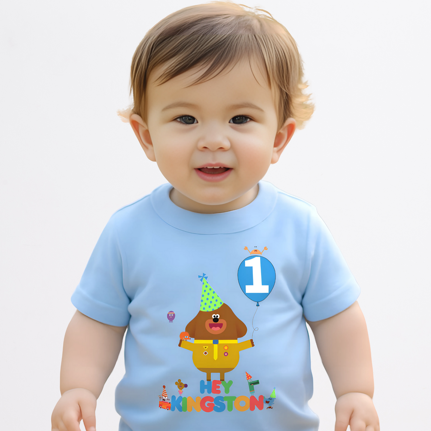 hey duggee birthday t-shirt: A vibrant and colourful Hey Duggee birthday t-shirt for boys, featuring Hey Duggee and the Squirrels. The toddler birthday shirt is personalised with the child's name and age, displayed within a cheerful blue balloon. Toddler birthday t-shirt, gift ideas for toddlers, personalised hey duggee shirt