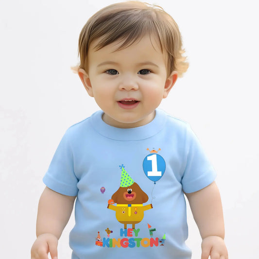 hey duggee birthday t-shirt: A vibrant and colourful Hey Duggee birthday t-shirt for boys, featuring Hey Duggee and the Squirrels. The toddler birthday shirt is personalised with the child's name and age, displayed within a cheerful blue balloon. Toddler birthday t-shirt, gift ideas for toddlers, personalised hey duggee shirt