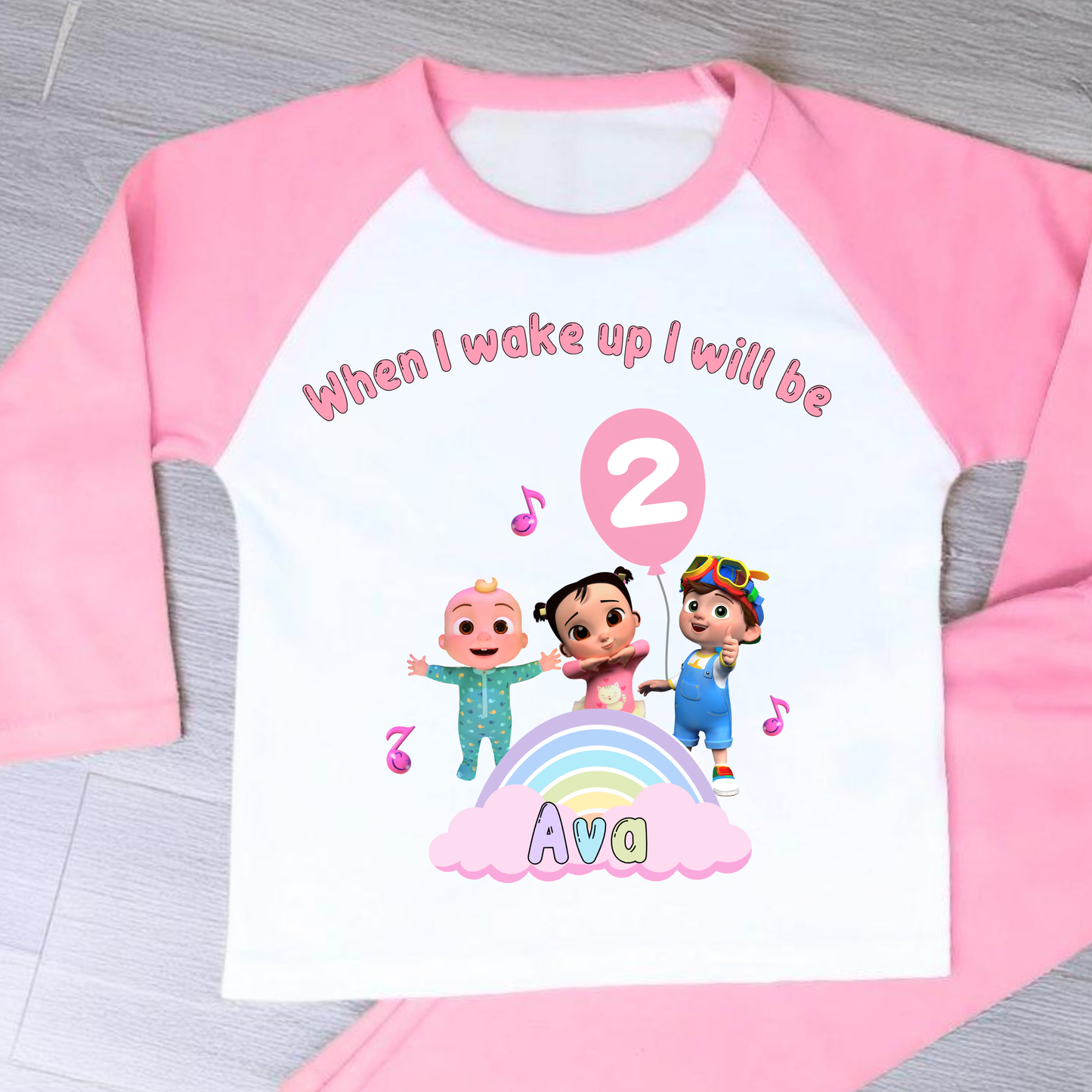 Cocomelon Birthday Pyjamas: Image of a set of Cocomelon Birthday Pyjamas for children, displayed on a soft, pastel-hued background. The pyjamas are made from a soft fabric and showcase a pastel rainbow color scheme, adorned with popular Cocomelon characters. The ensemble is designed to be both stylish and comfortable, making it perfect for birthday celebrations or a cosy night. The image emphasizes the playful and whimsical nature of the pyjamas, capturing the essence of fun for young fans of Cocomelon.