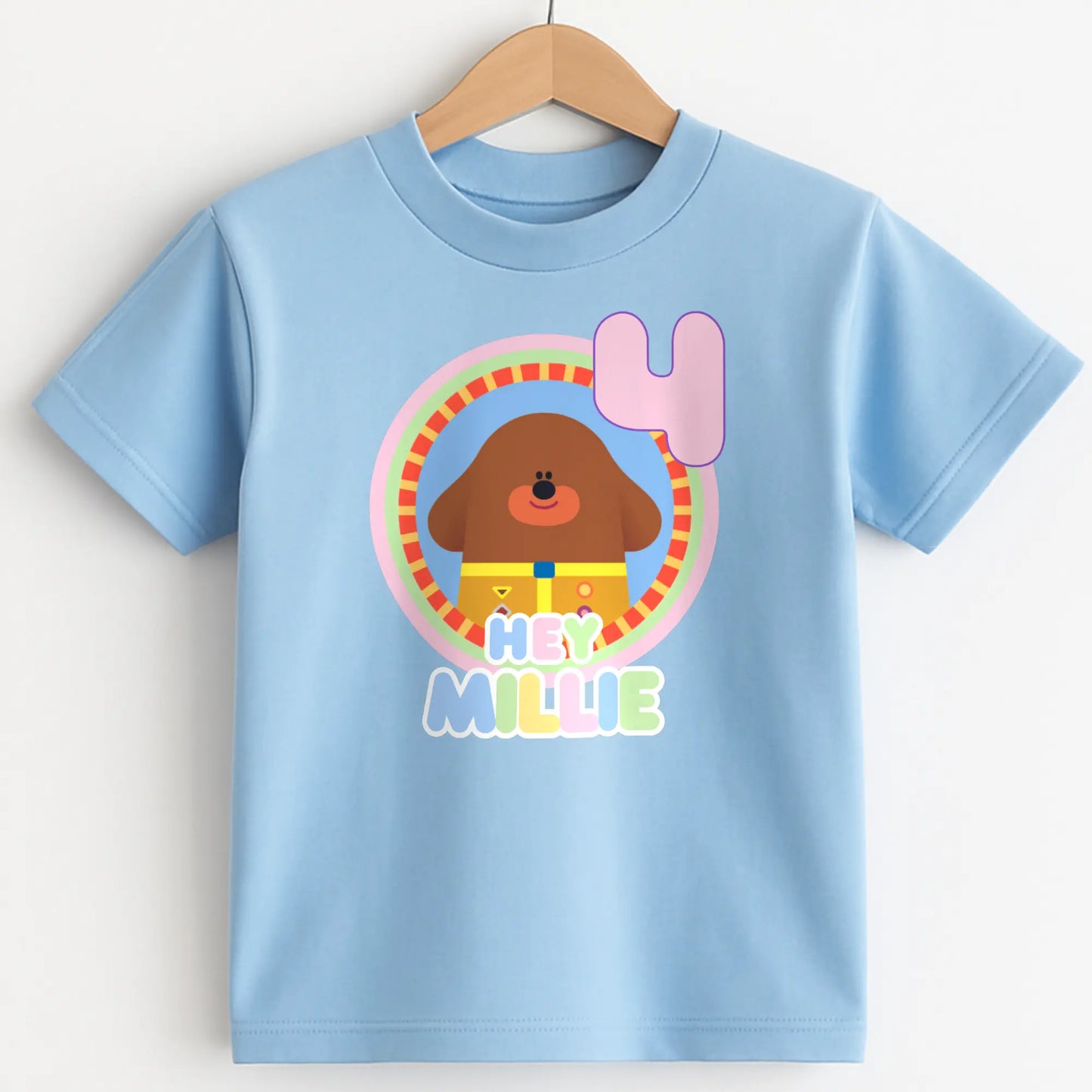 Hey Duggee Badge Birthday T-shirt: A lively and vibrant birthday t-shirt featuring the beloved character Hey Duggee, perfect for a child's special day. The shirt is customisable with the child's name and age, making it a personal keepsake. Made from 100% cotton, it promises comfort and durability for active play. The design's bright colours and the iconic Hey Duggee badge add a delightful touch that reflects the child's unique personality and love for the popular children's series.