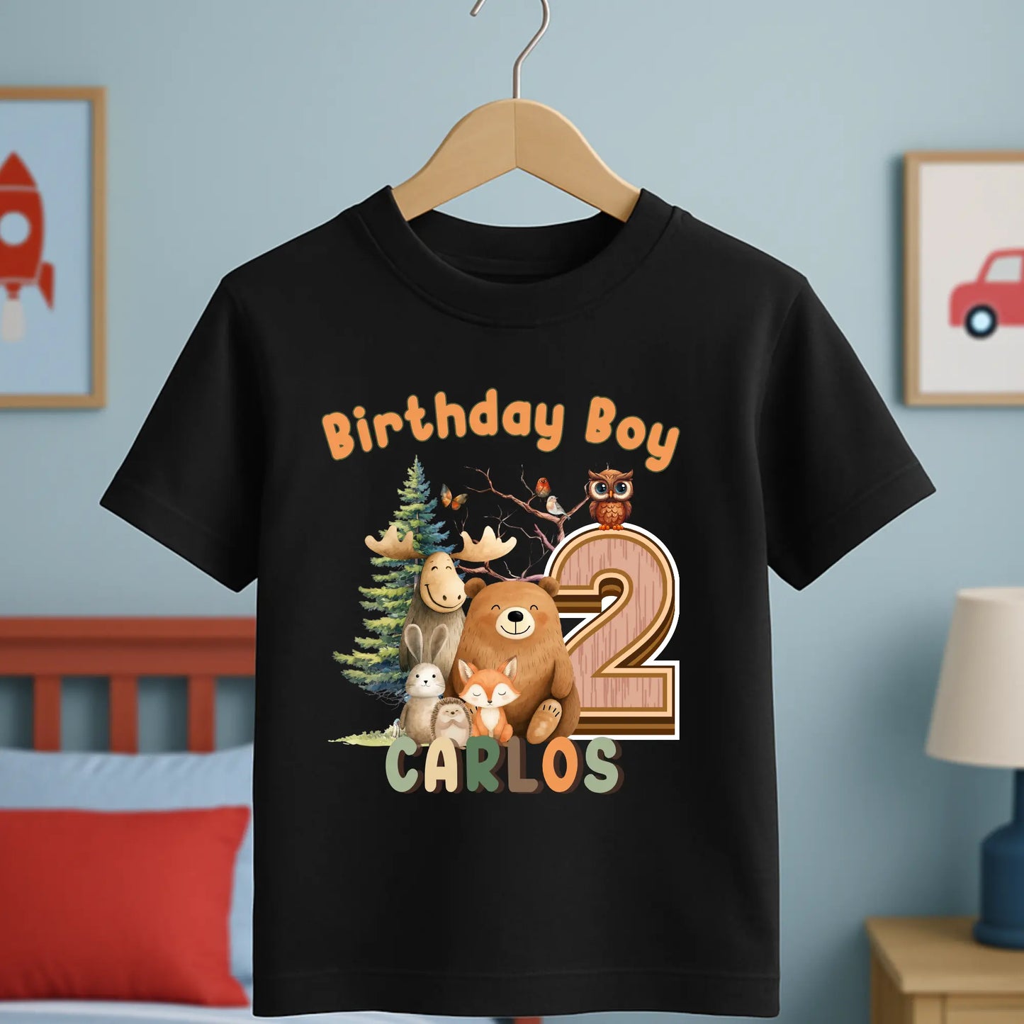 Woodland animal birthday t-shirt: A children's birthday t-shirt featuring a woodland animal theme. The shirt displays a forest scene with a playful fox, a curious bear, and a gentle bear, surrounded by lush greenery. The design uses earthy tones and vibrant greens to create a natural look. At the top, the words “Birthday Boy” are printed, with space for a personalized name underneath. Made from soft, high-quality fabric, it’s designed for comfort and durability.