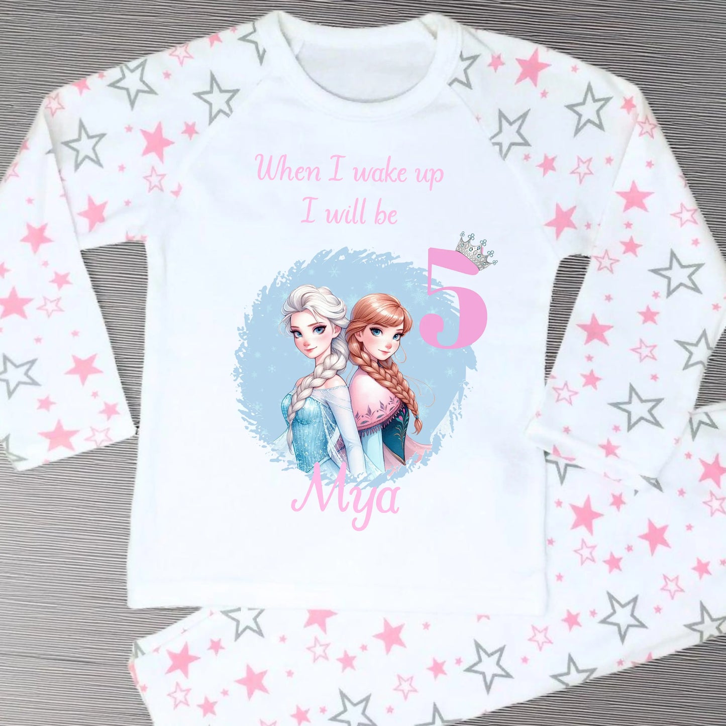 Personalised Frozen birthday pyjamas with name and age. Features Elsa and Anna in Frozen colours of blue and lilac. Perfect for birthday morning photos and celebrations.