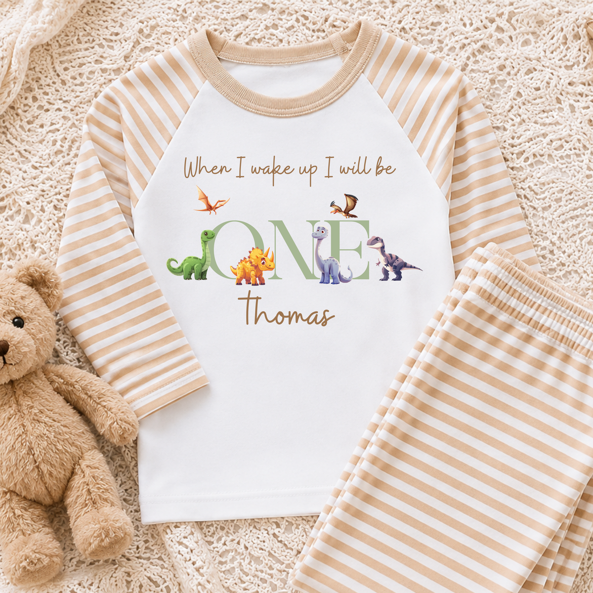 Personalised Boys Dinosaur Birthday Pyjamas with child's name and age, featuring colourful dinosaurs, long-sleeve top and coordinating striped bottoms.