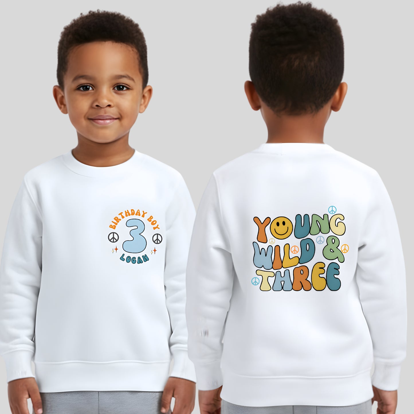 Personalised Young Wild and three birthday sweatshirt: A boys birthday sweatshirt with a Young Wild and Three theme, showcasing a groovy retro style. The front features whimsical retro emojis and the words birthday boy alongside a custom name on the left breast. The back displays bold retro fonts and graphics. Tthis vibrant and playful tee is designed for comfort and style, perfect for third birthday gifts.