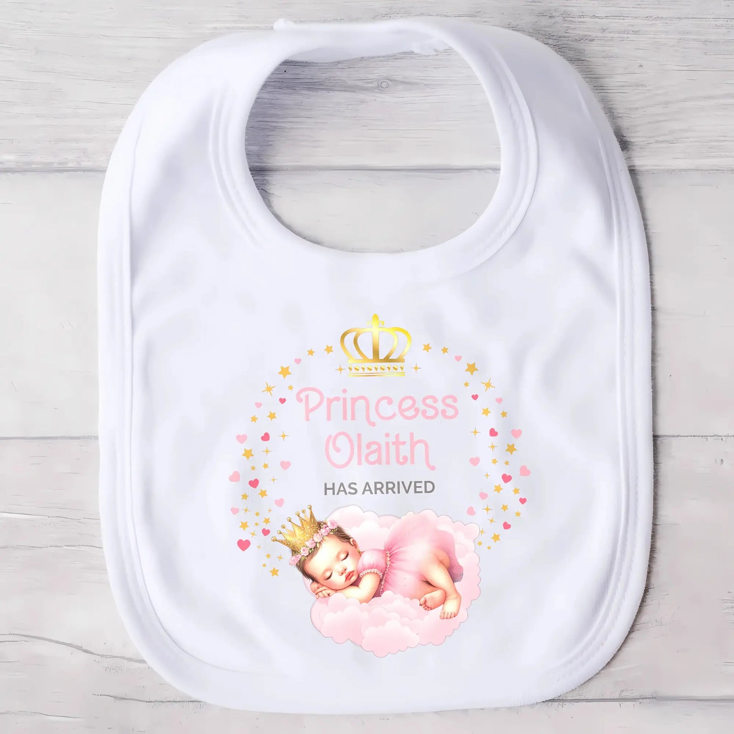 Personalised baby outfit: A collection of vibrant and charming baby clothes, featuring sleepsuits, bodysuits, T-shirts, and bibs, all designed for baby girls. The items are part of the “Personalised Baby Girls The Princess Has Arrived” collection.. The collection allows for customisation with a baby’s name, making these pieces ideal for gifts or special occasions. This will make a great newborn baby gift for gender reveal, baby shower, or to welcome a new baby coming home outfit.