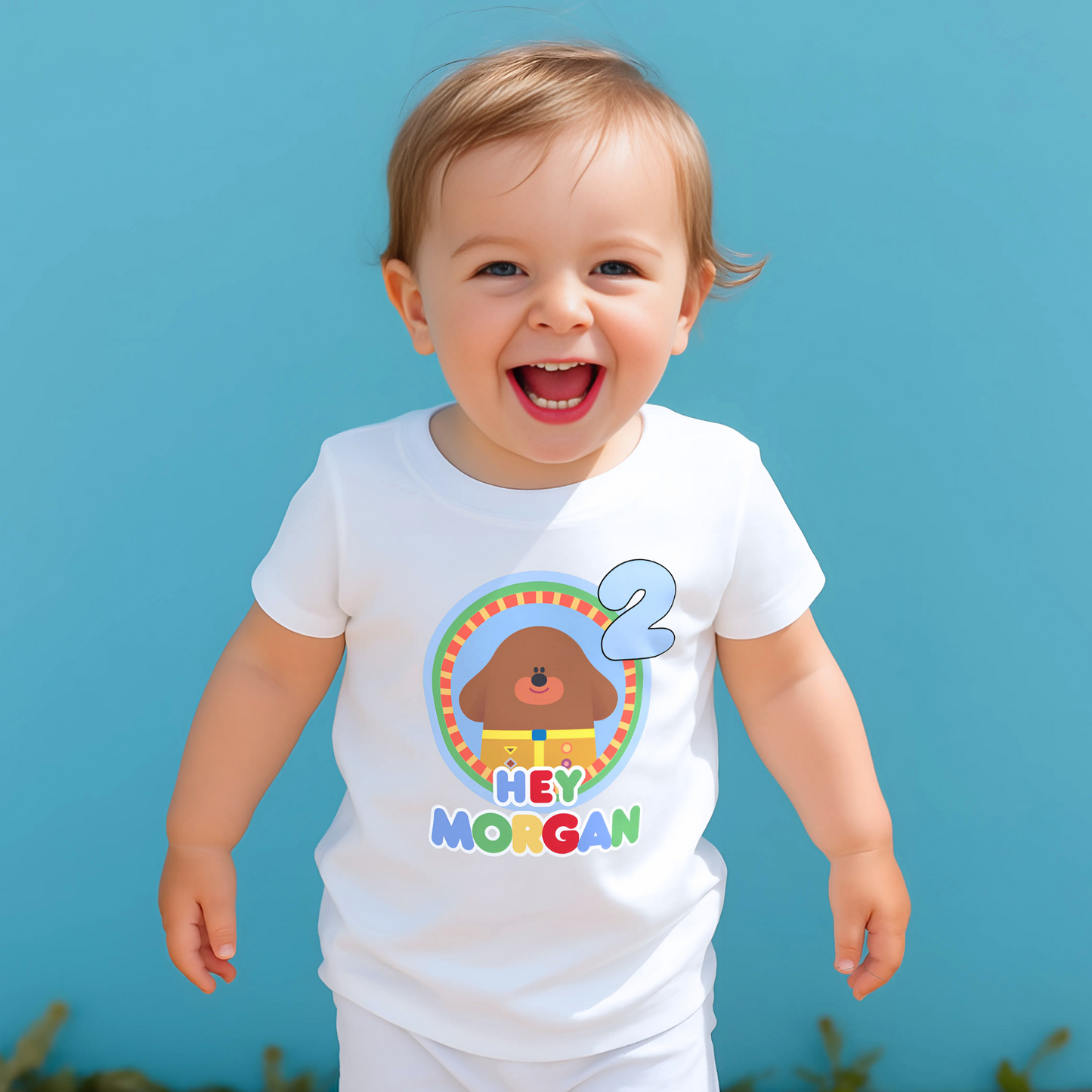 Hey Duggee Badge Birthday T-shirt: A lively and vibrant birthday t-shirt featuring the beloved character Hey Duggee, perfect for a child's special day. The shirt is customisable with the child's name and age, making it a personal keepsake. Made from 100% cotton, it promises comfort and durability for active play. The design's bright colours and the iconic Hey Duggee badge add a delightful touch that reflects the child's unique personality and love for the popular children's series.