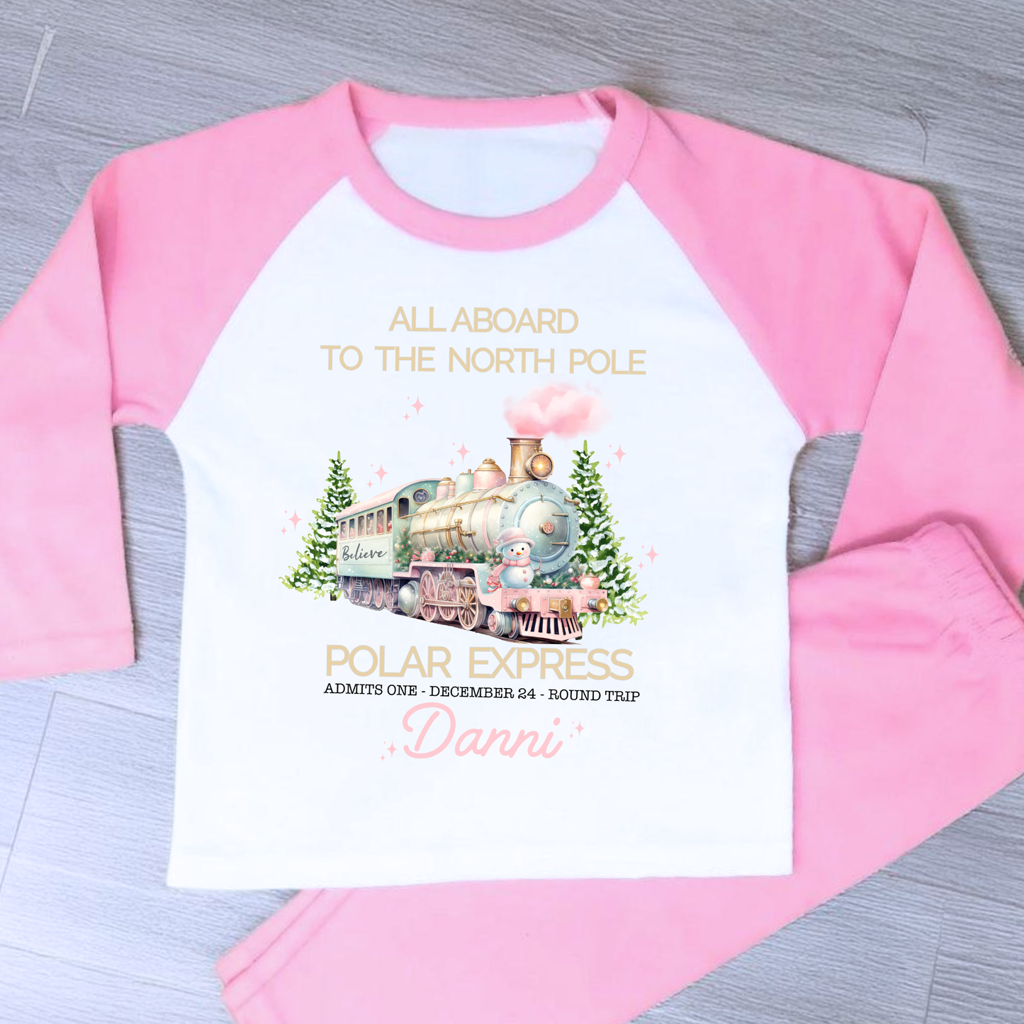 Polar express christmas pyjamas: A set of pink polar express Christmas Eve pyjamas for girls, personalised with a name. These pyjamas are designed to evoke the magic and wonder of the holiday season, made from soft, breathable fabric for a cozy night's sleep. Perfect for dreaming of a Polar Express journey to the North Pole. Girls polar express christmas pjs, christmas pyjamas personalised