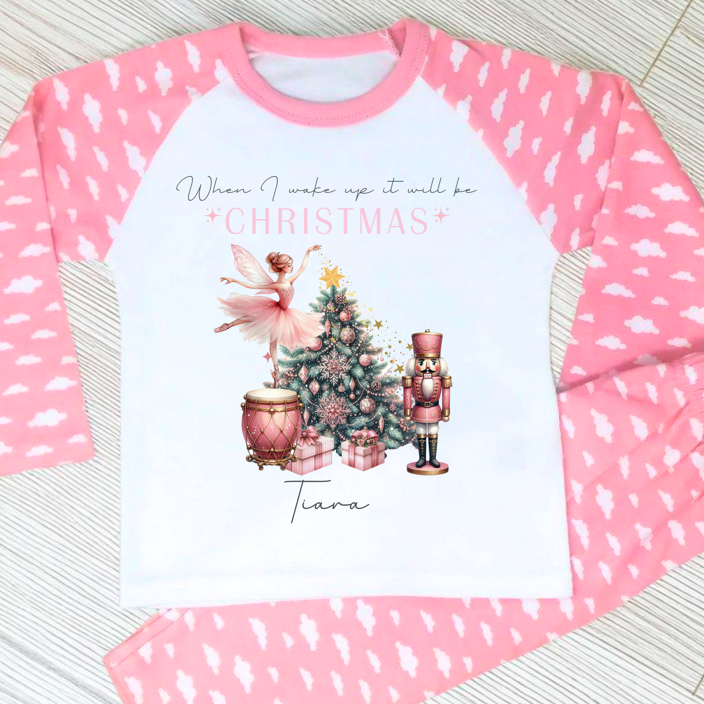 Girls personalised Christmas pyjamas featuring a beautifully illustrated ballerina as a Christmas fairy in dusky pink hues with nutcracker motifs in gold. These enchanting pyjamas offer a personalisation option to add a name, making them unique and ideal for gifting. Perfect for the Christmas season, they bring joy and become a treasured keepsake. Personalised Nutcracker Christmas Pyjamas, when i wake up it will be christmas