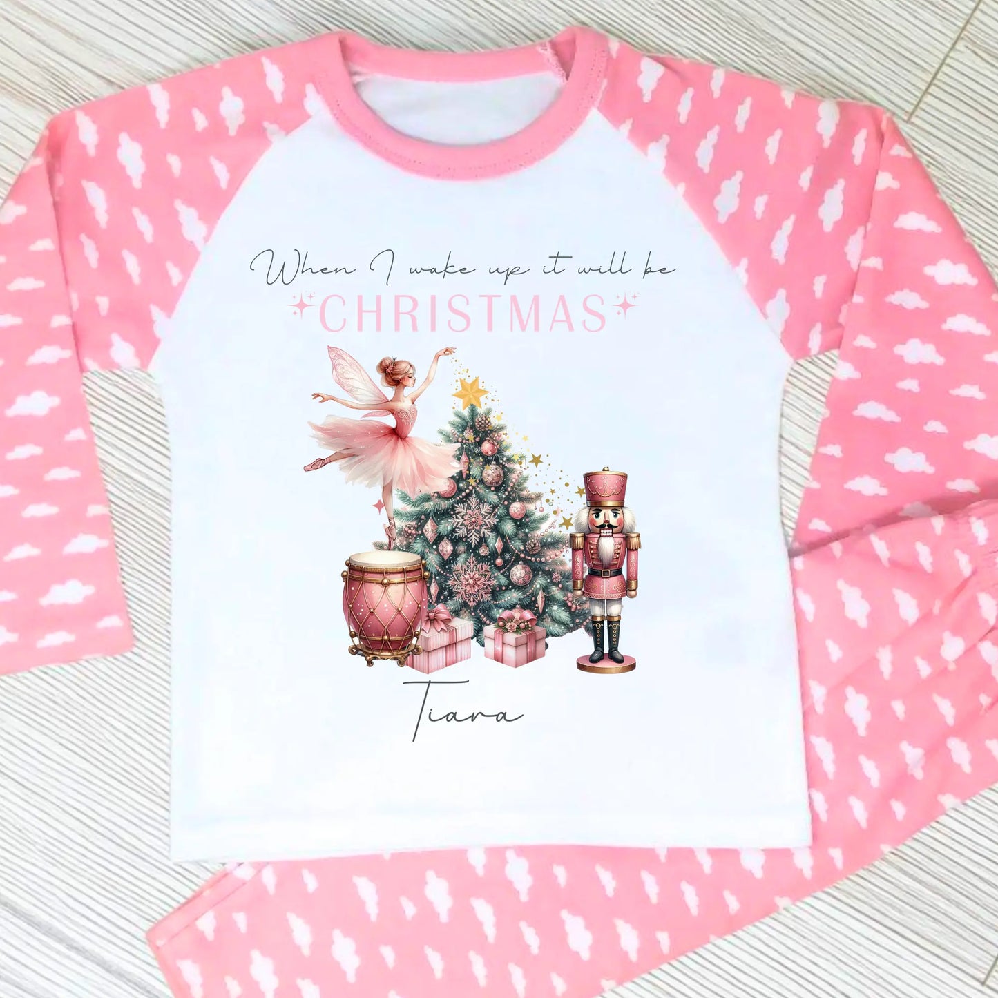 Girls personalised Christmas pyjamas featuring a beautifully illustrated ballerina as a Christmas fairy in dusky pink hues with nutcracker motifs in gold. These enchanting pyjamas offer a personalisation option to add a name, making them unique and ideal for gifting. Perfect for the Christmas season, they bring joy and become a treasured keepsake. Personalised Nutcracker Christmas Pyjamas, when i wake up it will be christmas