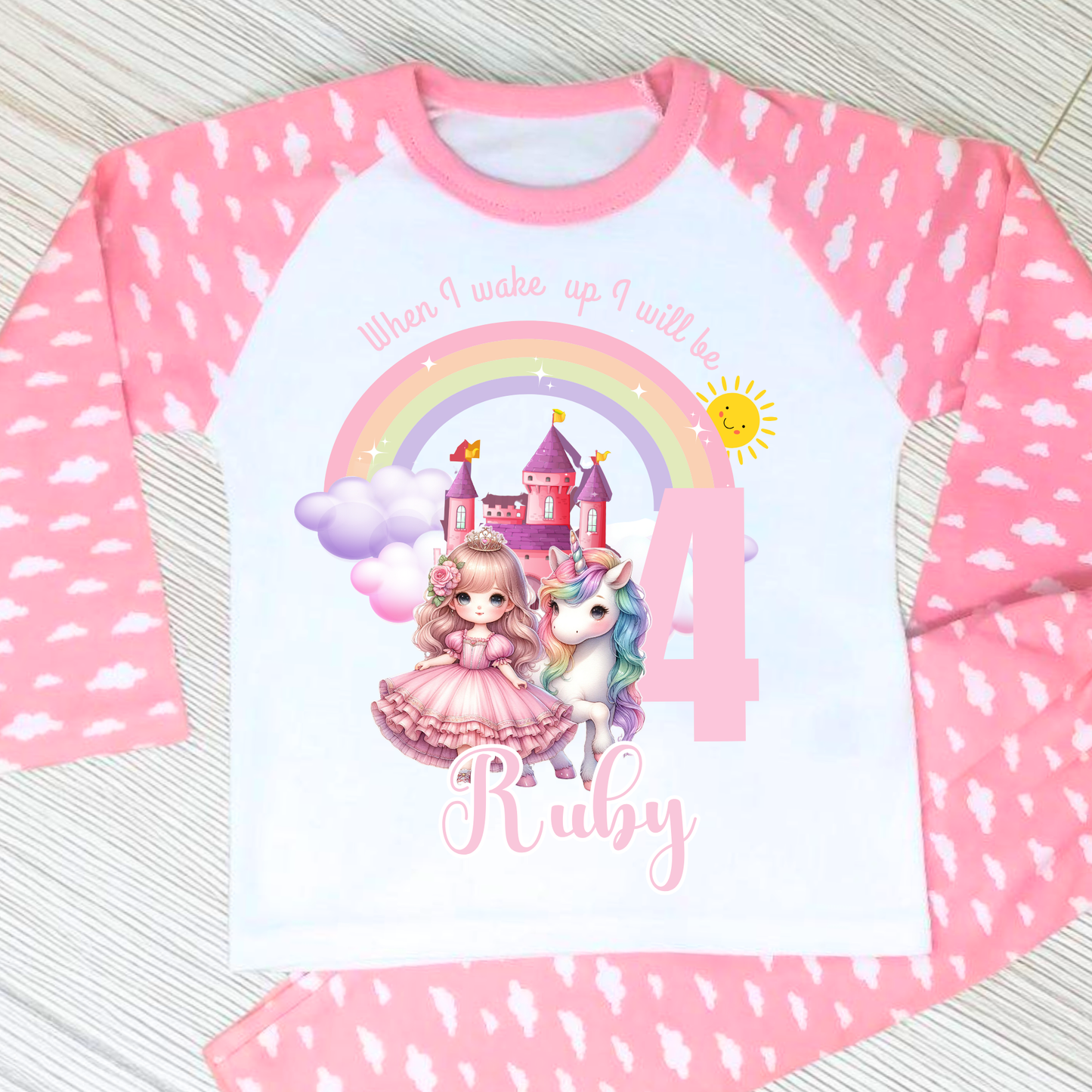 Princess Birthday Pyjamas: A pink and white long-sleeved pyjama set with a rainbow, castle, unicorn, and a princess in a pink dress. The top has the text 'When I wake up I will be with age and name. It will be a perfect personalised gift for a girls birthday to compliment a princess unicorn birthday party.