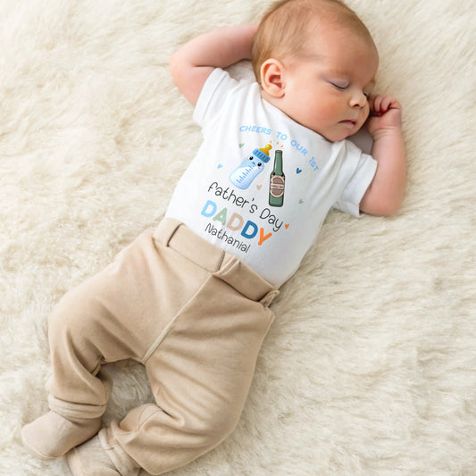 1st Father’s Day Outfit featuring a cute Daddy and Baby drinks toast design, available as a baby sleepsuit, vest, T-shirt or bib.