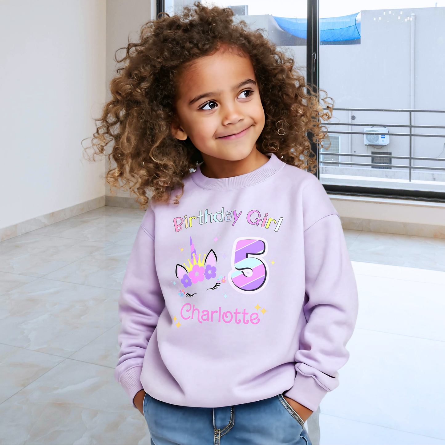 Unicorn Birthday Sweatshirt, A personalised birthday jumper for girls, featuring a pink and purple unicorn design. The sweatshirt is customisable with the child's name and age, making it a perfect birthday gift. The vibrant colours and whimsical unicorn imagery make it an ideal choice for a toddler celebrating her special day.