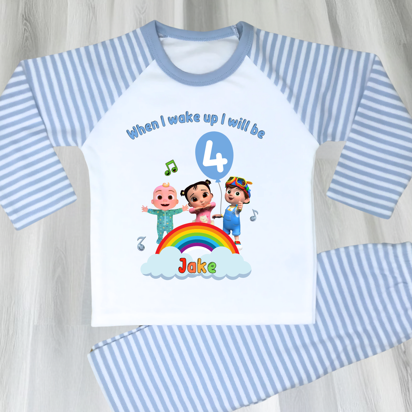 Cocomelon birthday pyjamas for boys with custom name and age, rainbow design with favourite Cocomelon characters, birthday number in blue balloon, and name printed under fluffy clouds, soft and comfy sleepwear set for birthday mornings