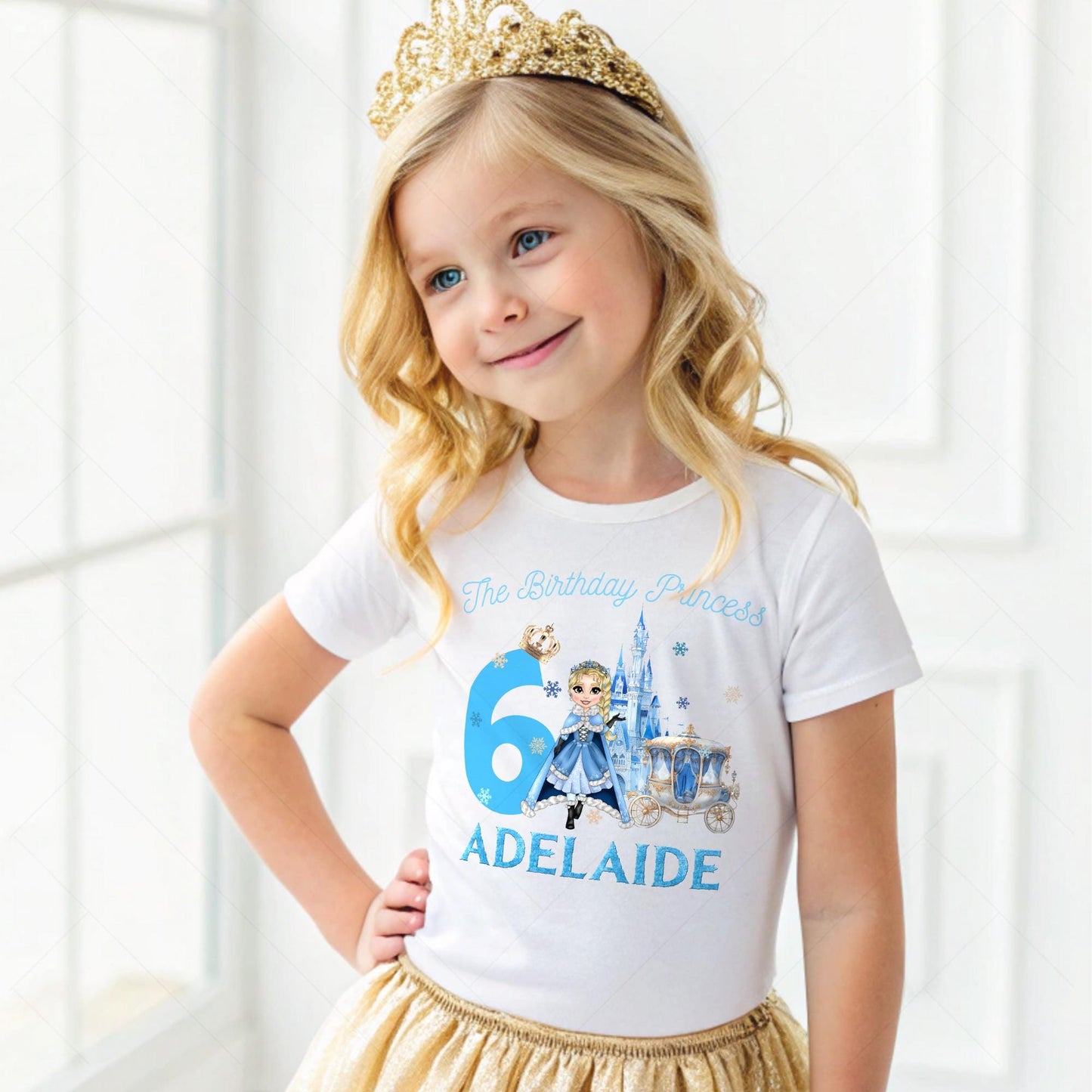 A charming, personalized girls' birthday T-shirt designed for a princess-themed celebration. The design is a soft blue, reminiscent of an ice princess's gown, crafted from 100% cotton for comfort. Its front features a delightful illustration of a snow princess, surrounded by delicate snowflakes. The design is completed with customizable elements, displaying a name and age in elegant, white script. This tee is perfect for creating a magical birthday experience for any young princess.