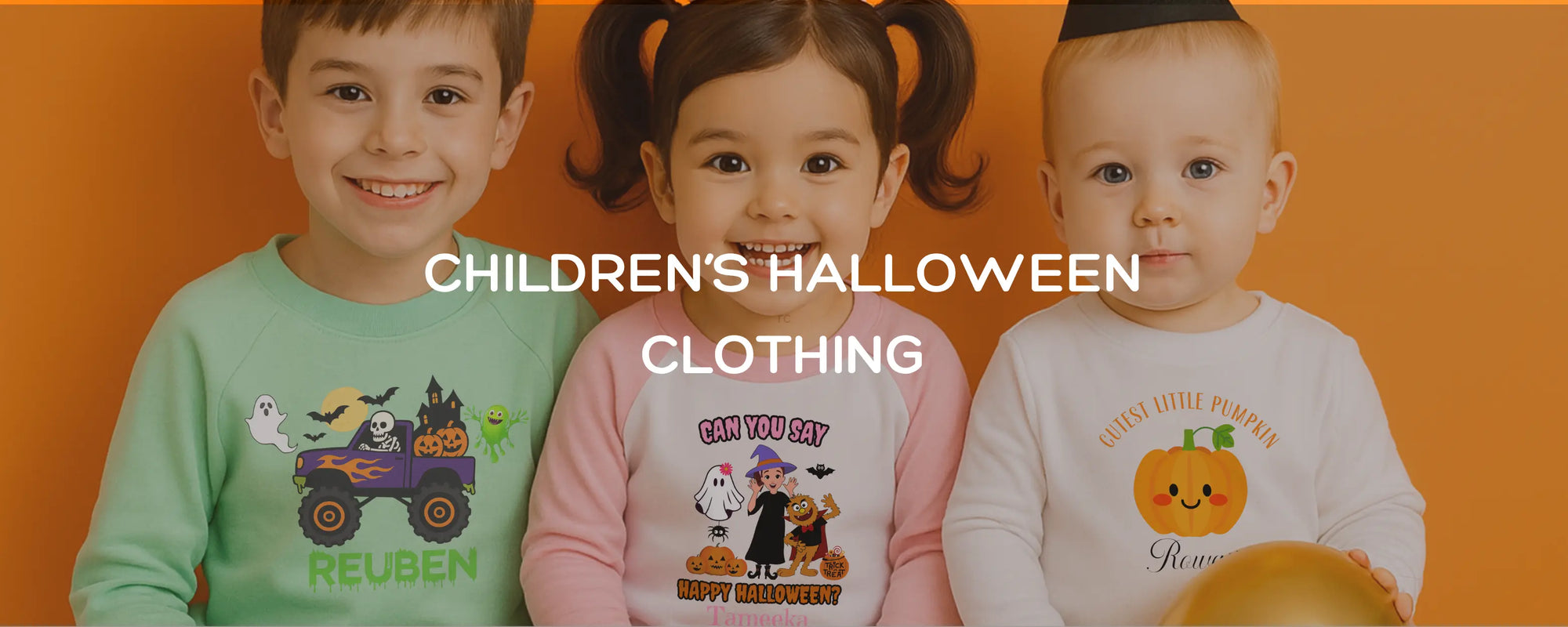 A banner of three children wearing personalised Halloween clothing. Two wearing Halloween jumpers and the girl wearing pyjamas