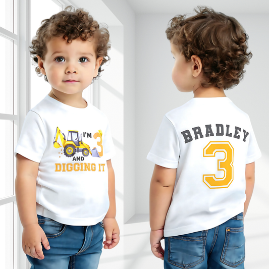 Excavator Digger Birthday T-Shirt: This white t-shirt features a vibrant yellow excavator graphic alongside the playful text “I am digging it,” with customizable age options to celebrate a birthday. The back is personalised with the boy name and age in bold yellow with a black outline. Ideal as a gift for a boy or toddler birthday or a construction-themed party.