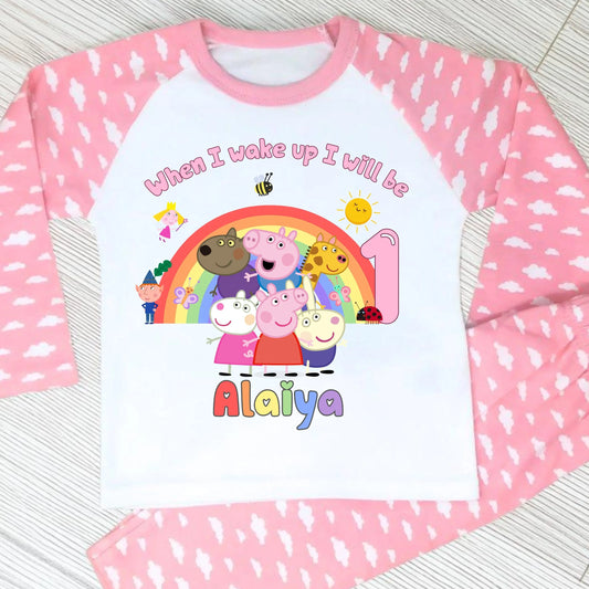 Pink Peppa Pig and friends personalised girls birthday pyjamas featuring a rainbow design and the text “When I wake up I will be with custom age and name, printed on a soft long-sleeve top and matching pink bottoms. Perfect personalised Peppa Pig birthday outfit for toddlers, ideal for first second third birthday celebrations, gifts, and bedtime photos.