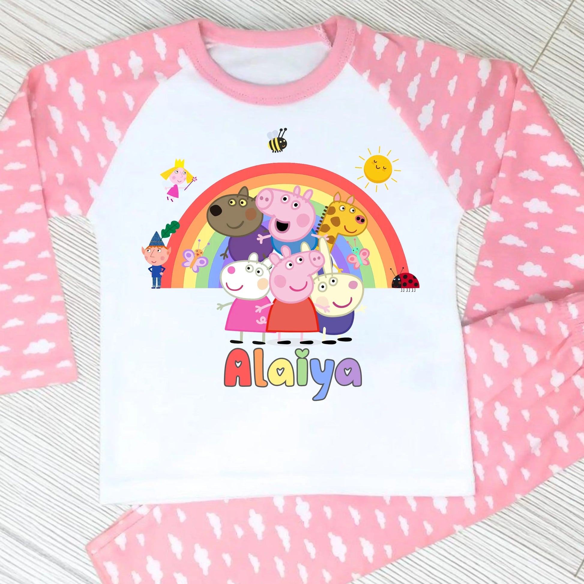 Pink Peppa Pig personalised girls pyjamas set featuring a colourful rainbow design and favourite Peppa Pig characters, customised with name and age. Made from soft, comfortable fabric with a long-sleeve top and matching cloud-print bottoms. Perfect for everyday wear, cosy nights, and relaxed mornings—ideal personalised Peppa Pig sleepwear for toddlers and young children.