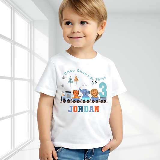 White cotton t-shirt featuring a vibrant safari jungle theme designed for a boy's birthday party. The top is personalised with the phrase ‘Choo Choo I'm Two,’ or any age, and adorned with playful illustrations of jungle animals like lions, elephants, and giraffes, perfect for a safari-themed celebration. Also for boys that love trains. Boys toddler birthday shirt, personalised toddler gift ideas, jungle animal themed birthday party ideas.