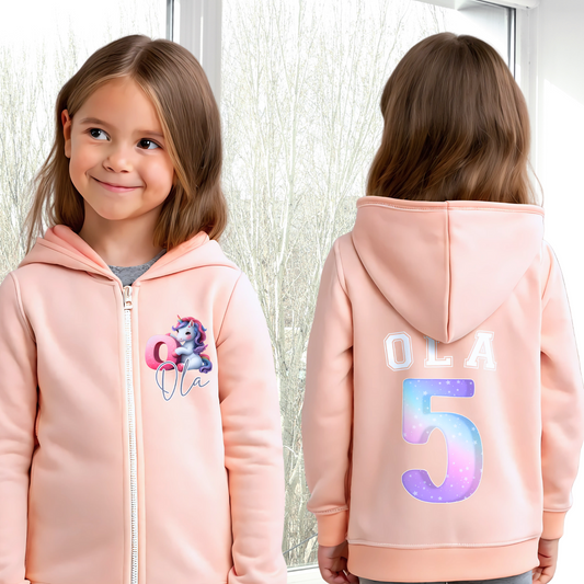 girls unicorn hoodie: A personalised girl's zip-up hoodie featuring a colourful unicorn graphic on the front, along with the girl's initial and name. The back showcases her name and favourite number. Perfect for a unicorn-themed birthday celebration! Custom girls hoodie, unicorn graphic jacket, personalised name and number hoodie, unicorn-themed apparel, birthday hoodie for girls.