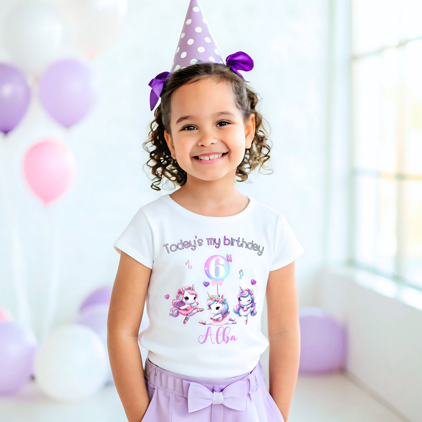 A pastel pink and lilac unicorn birthday T-shirt for girls and toddlers, featuring a cute unicorn design. Made from soft, breathable 100% cotton, this shirt offers both style and comfort. It can be personalised with a name, making it a unique birthday gift for girls. Perfect for a little dancer's birthday celebration, combining magic and comfort as she twirls and plays. Unicorn birthday gift, personalised unicorn, custom name tshirt
