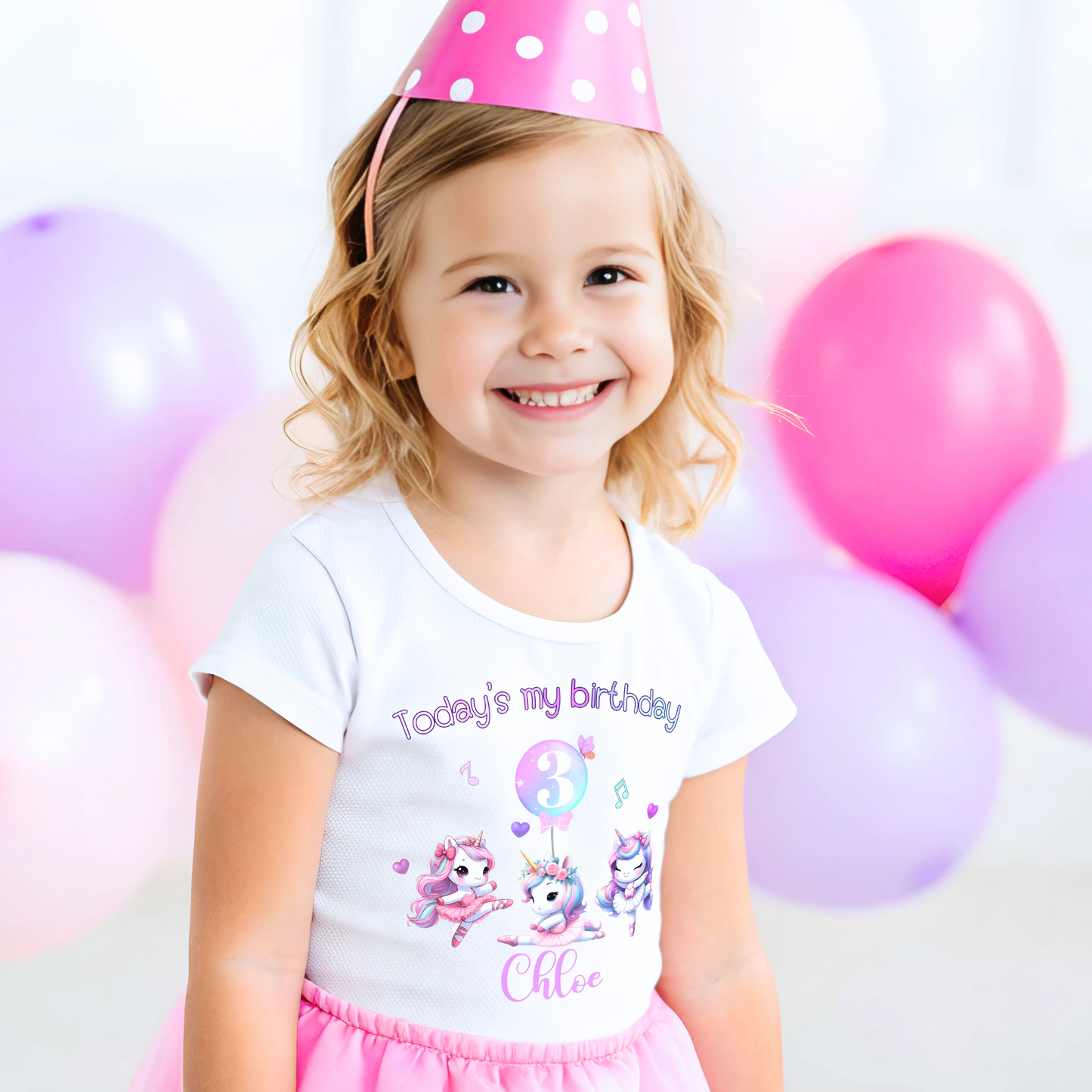 A pastel pink and lilac unicorn birthday T-shirt for girls and toddlers, featuring a cute unicorn design. Made from soft, breathable 100% cotton, this shirt offers both style and comfort. It can be personalised with a name, making it a unique birthday gift for girls. Perfect for a little dancer's birthday celebration, combining magic and comfort as she twirls and plays. Unicorn birthday gift, personalised unicorn, custom name tshirt