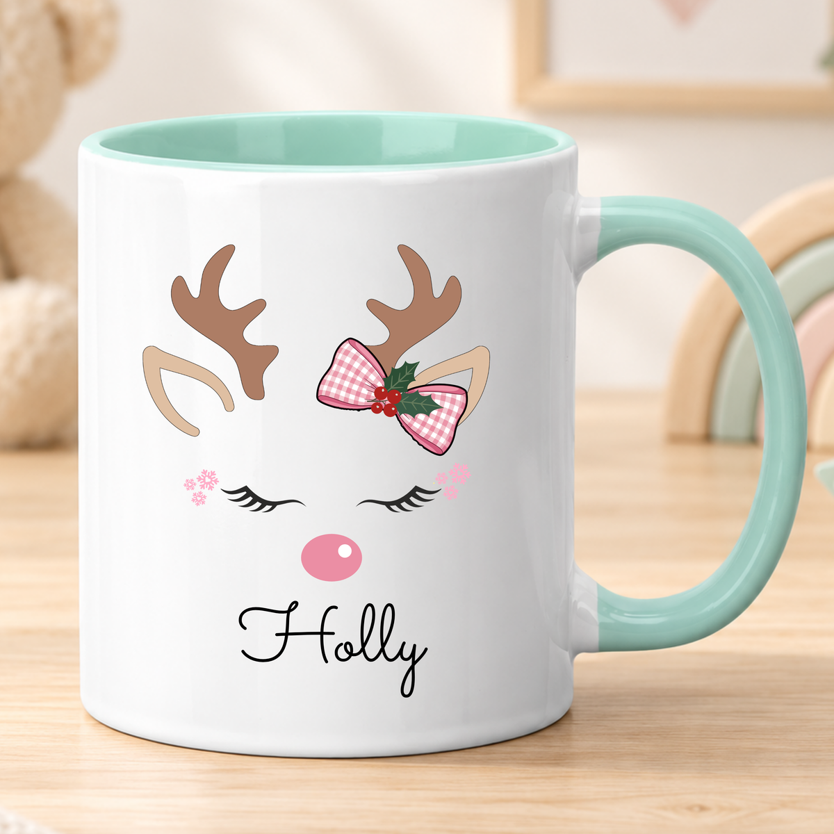 Personalised reindeer Christmas mug for girls featuring a pink bow and child’s name, available in polymer, ceramic and campervan styles.