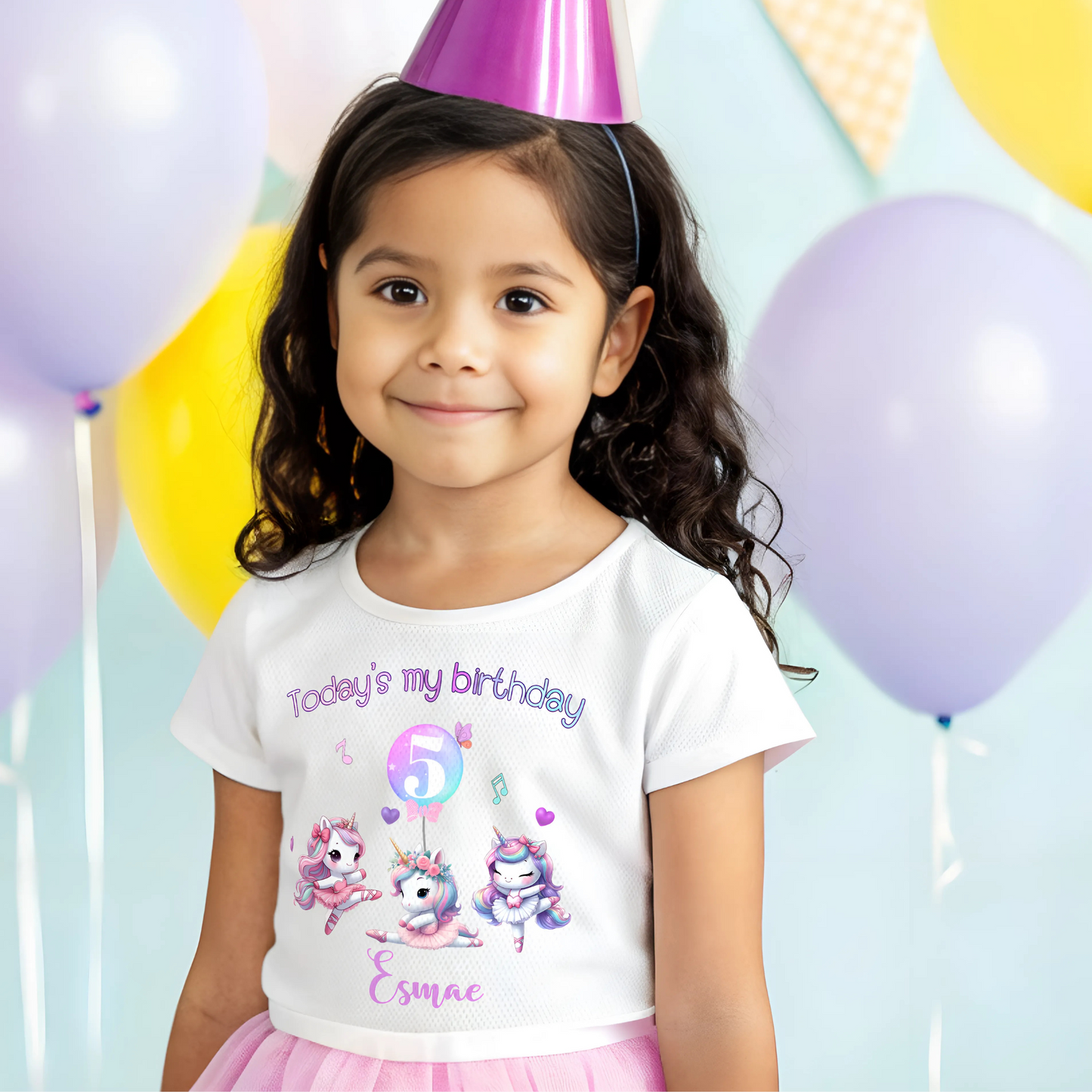 A pastel pink and lilac unicorn birthday T-shirt for girls and toddlers, featuring a cute unicorn design. Made from soft, breathable 100% cotton, this shirt offers both style and comfort. It can be personalised with a name, making it a unique birthday gift for girls. Perfect for a little dancer's birthday celebration, combining magic and comfort as she twirls and plays. Unicorn birthday gift, personalised unicorn, custom name tshirt