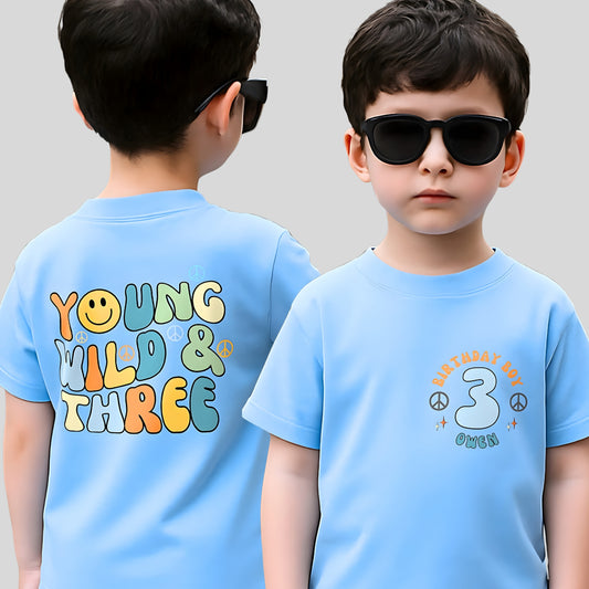 Personalised Young Wild and three birthday t-shirt: A boys birthday T-shirt with a Young Wild and Three theme, showcasing a groovy retro style. The front features whimsical retro emojis and the words birthday boy alongside a custom name on the left breast. The back displays bold retro fonts and graphics. Tthis vibrant and playful tee is designed for comfort and style, perfect for third birthday gifts.