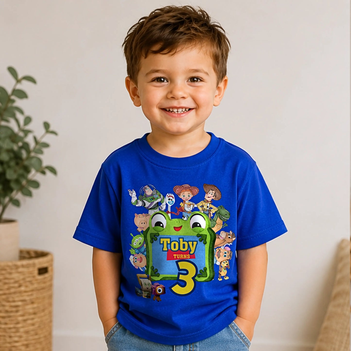 Personalised Toy Story birthday T-shirt for boys featuring custom name and age with colourful Toy Story-inspired characters including Buzz, Woody and friends, perfect for a birthday party outfit, cake smash and birthday photos.