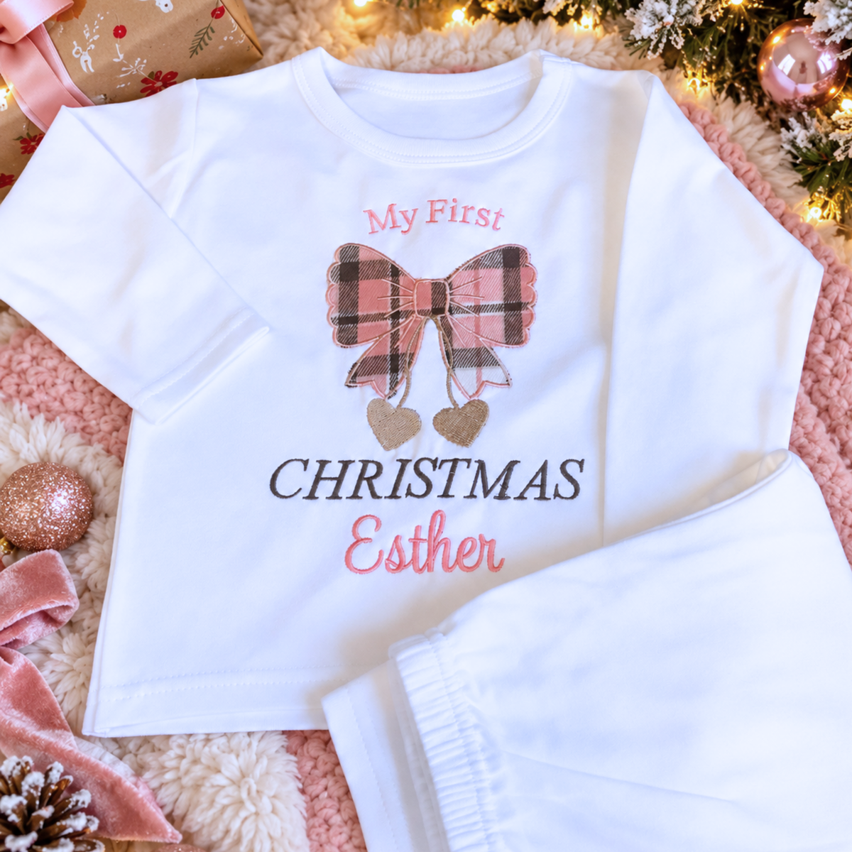 Personalised First Christmas Pyjamas for Girls with embroidered pink plaid tartan bow, gold hearts and name on white pyjamas