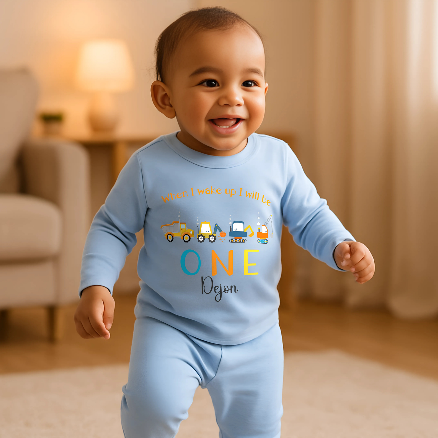 Personalised First Birthday pyjamas: personalised set of baby boy pyjamas for a first birthday,with a construction theme. The pyjamas display a playful design with diggers and excavators. The top reads: When I Wake Up I’ll Be ONE incorporating the child&#39;s name for a personalised touch. This set is ideal for toddlers who love construction vehicles, offering both comfort and a fun, imaginative theme: personalised baby pyjamas, first birthday, digger, excavator, custom name, construction vehicles.