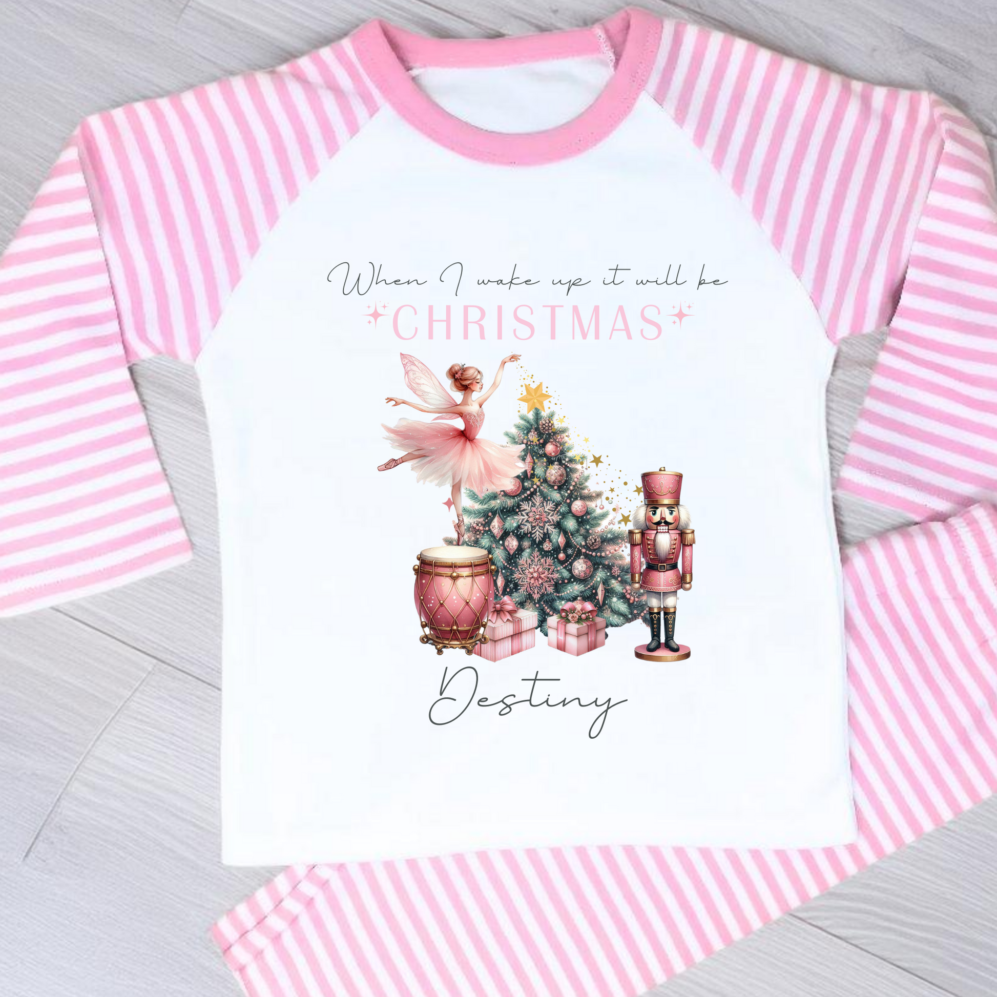 Girls personalised Christmas pyjamas featuring a beautifully illustrated ballerina as a Christmas fairy in dusky pink hues with nutcracker motifs in gold. These enchanting pyjamas offer a personalisation option to add a name, making them unique and ideal for gifting. Perfect for the Christmas season, they bring joy and become a treasured keepsake. Personalised Nutcracker Christmas Pyjamas, when i wake up it will be christmas