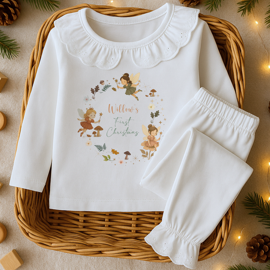 First Christmas Pyjamas: White baby pyjamas with fairy design and 'Willow's First Christmas' text on a woven basket.