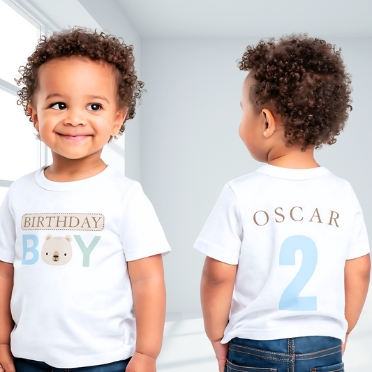 Teddy Bear Birthday T-shirt, Personalized Brown Bear Birthday T-Shirt: A charming white t-shirt showcasing a neutral theme with an adorable teddy bear head graphic and the words “Birthday Boy” in eye-catching beige, blue, and sage tones. The back is personalized with the child's name and age, making it the perfect birthday gift or celebration outfit for a toddler boy, ideal for memorable birthday photos and parties.