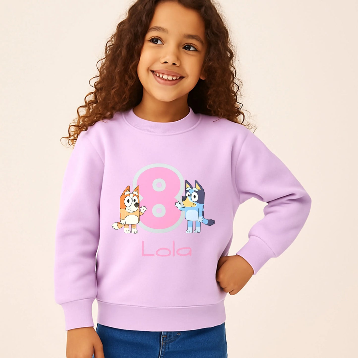 Persoalised Bluey and Bingo birthday sweatshirt: Child wearing a purple sweatshirt with bluey and bingo characters and her name underneath