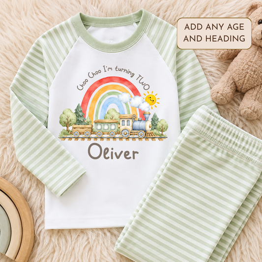 Personalised Train Birthday Two-Piece Set with watercolour steam train, rainbow, smiling sun and child's name. Available in sage green, beige and baby blue stripes.