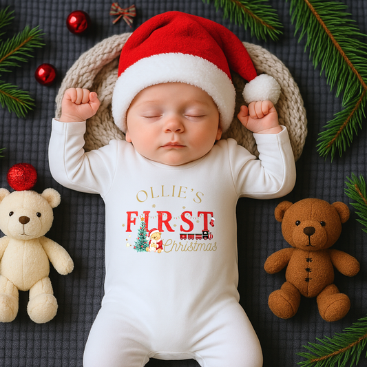 First Chrstmas Outfit, Baby wearing a 'First Christmas' onesie with Santa hat and Christmas decorations.