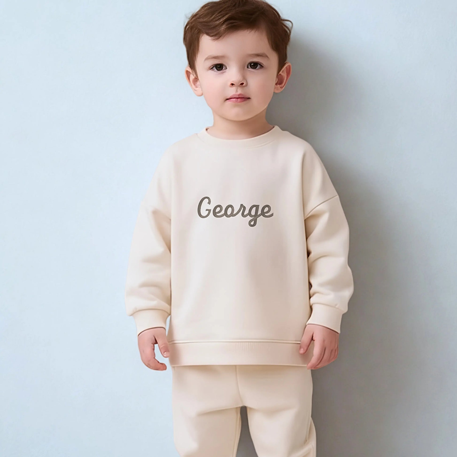 Personalised Embroidered Loungewear: A child wearing a two piece loungwear set with their name displayed on the front. Perfect for birthday and
