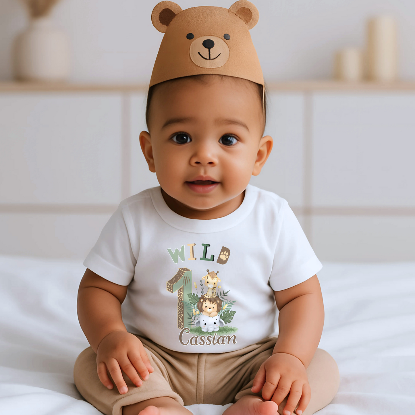 Wild One birthday t-shirt: A personalised Wild One 1st Birthday T-shirt for boys, featuring charming safari animals and vibrant colours. The shirt, designed for a jungle safari theme birthdays, includes space to customise with your child's name. Made from soft, high-quality materials, it promises comfort and style for your baby's first birthday celebration.