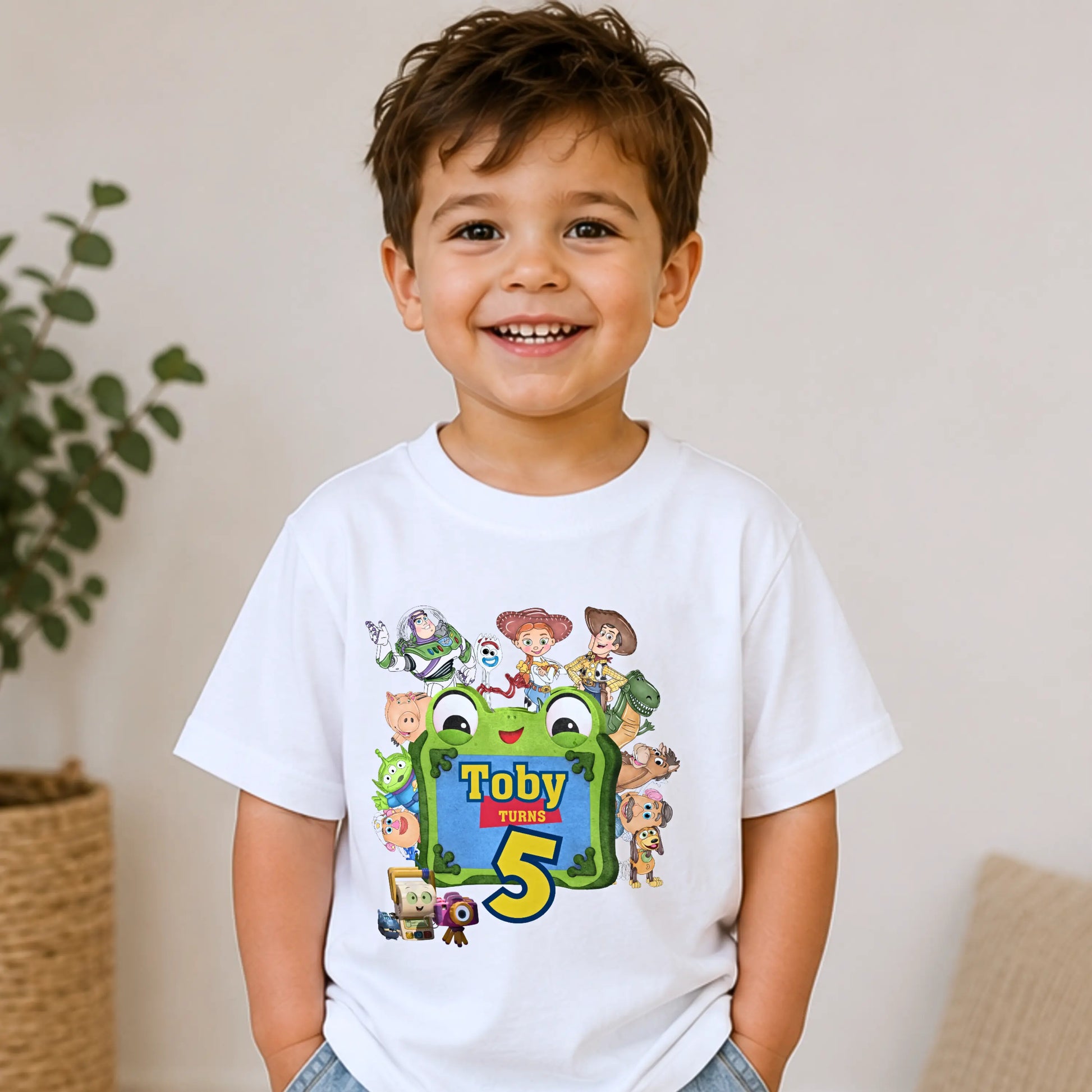 Personalised Toy Story birthday T-shirt for boys featuring custom name and age with colourful Toy Story-inspired characters including Buzz, Woody and friends, perfect for a birthday party outfit, cake smash and birthday photos.